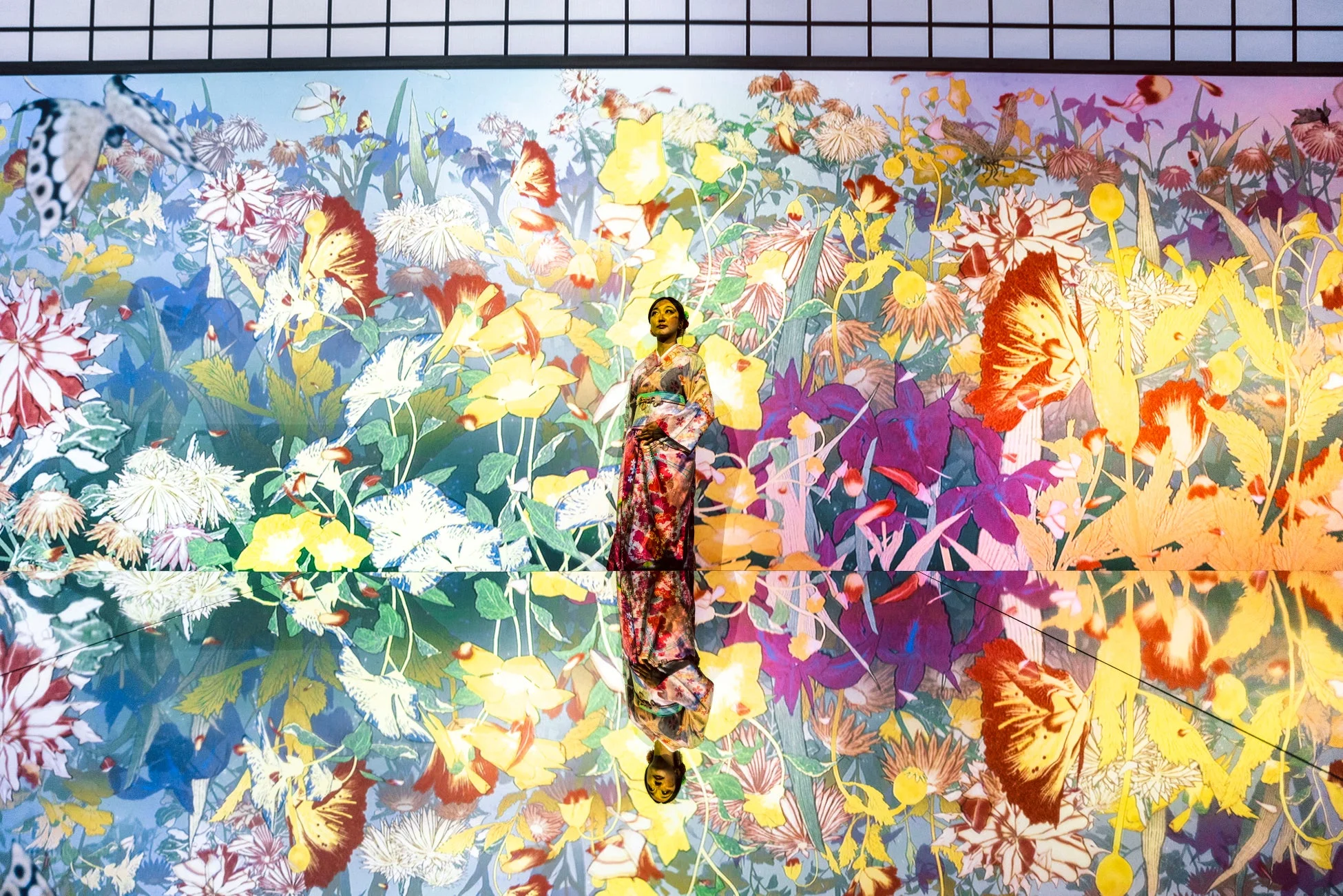 花と蝶のデジタルアート空間に立つ女性