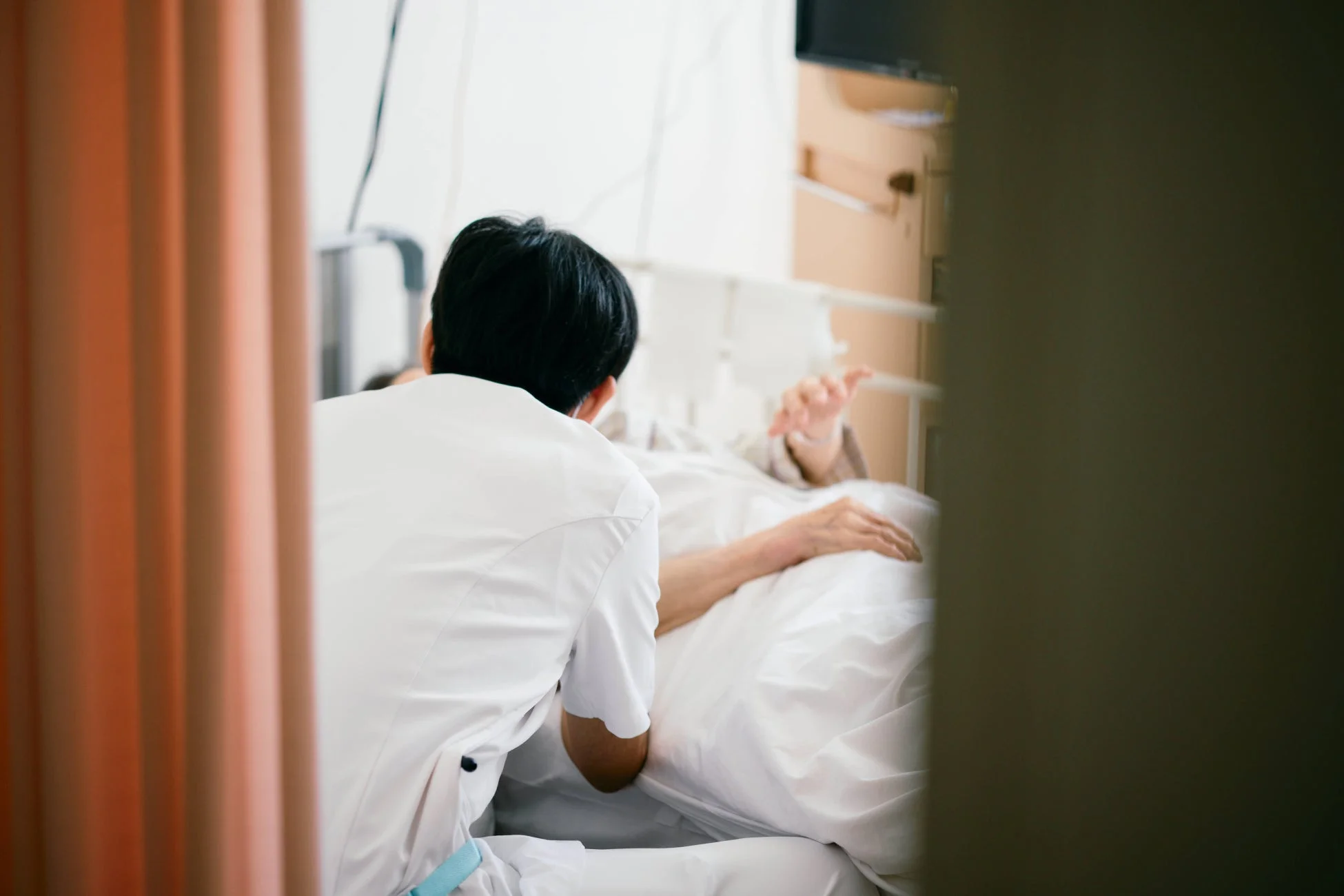 ベッドに横たわる患者をケアする医療従事者