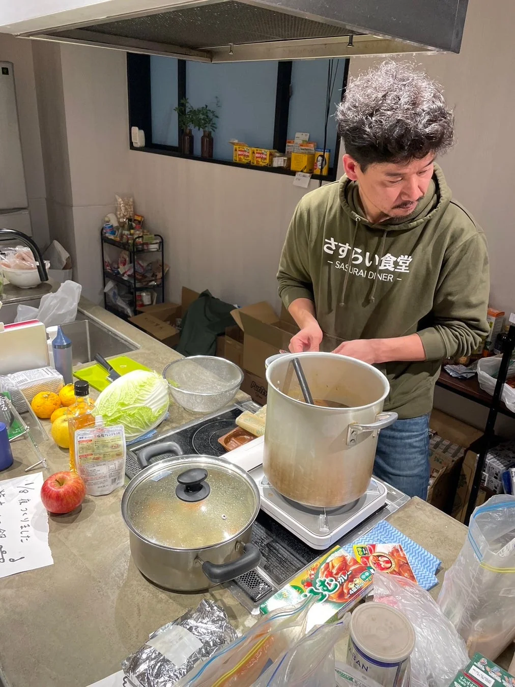 キッチンで料理する北村代表