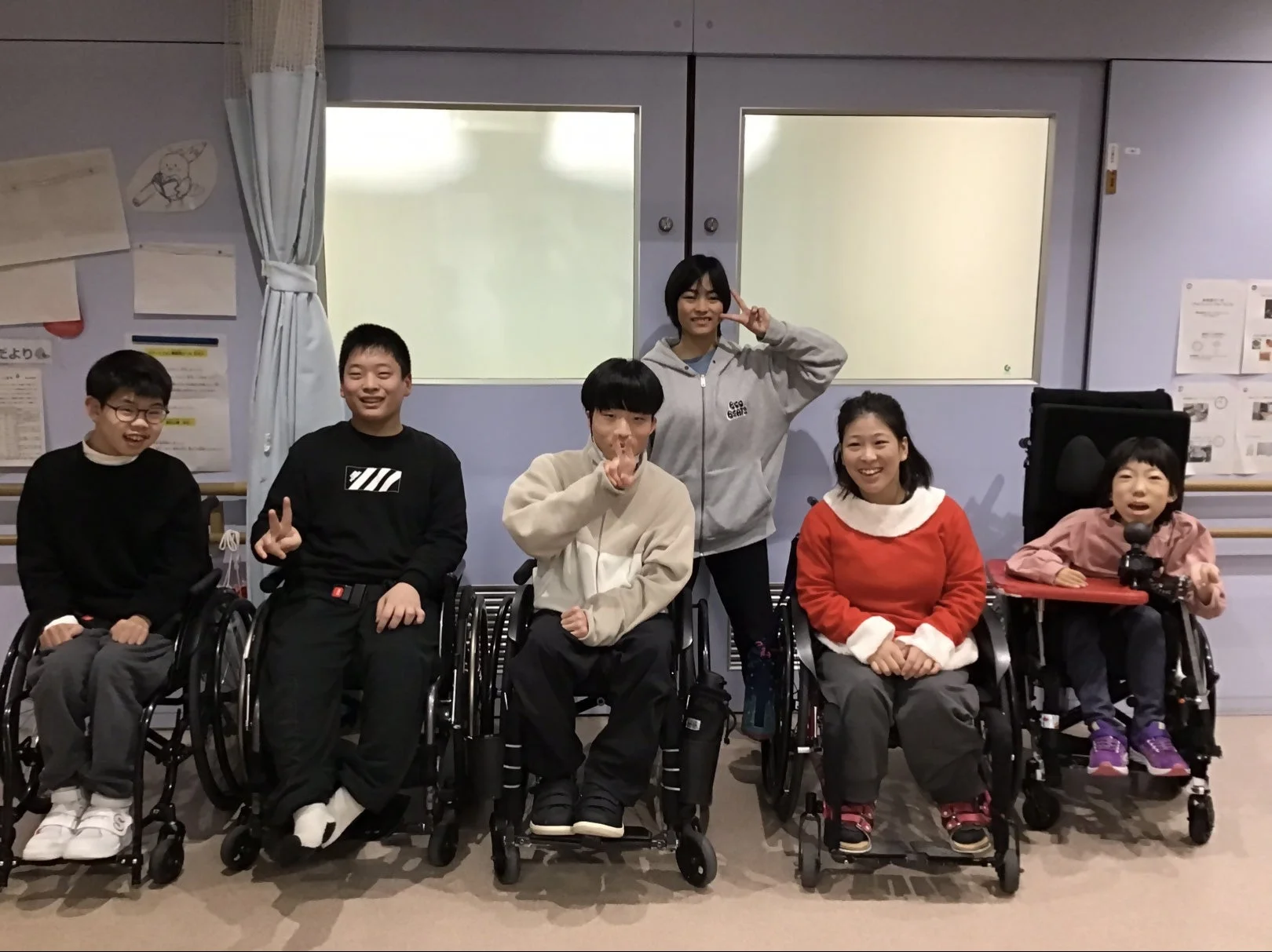 車椅子に乗った子どもたちと大人たちのグループ写真