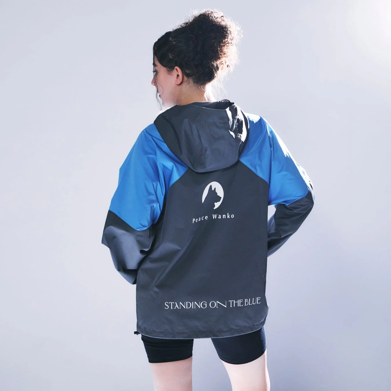 「Peace Wanko STANDING ON THE BLUE」のロゴが入ったジャケットの後ろ姿