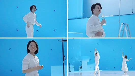 ブルーバックのスタジオで白い衣装のモデルが撮影に臨む