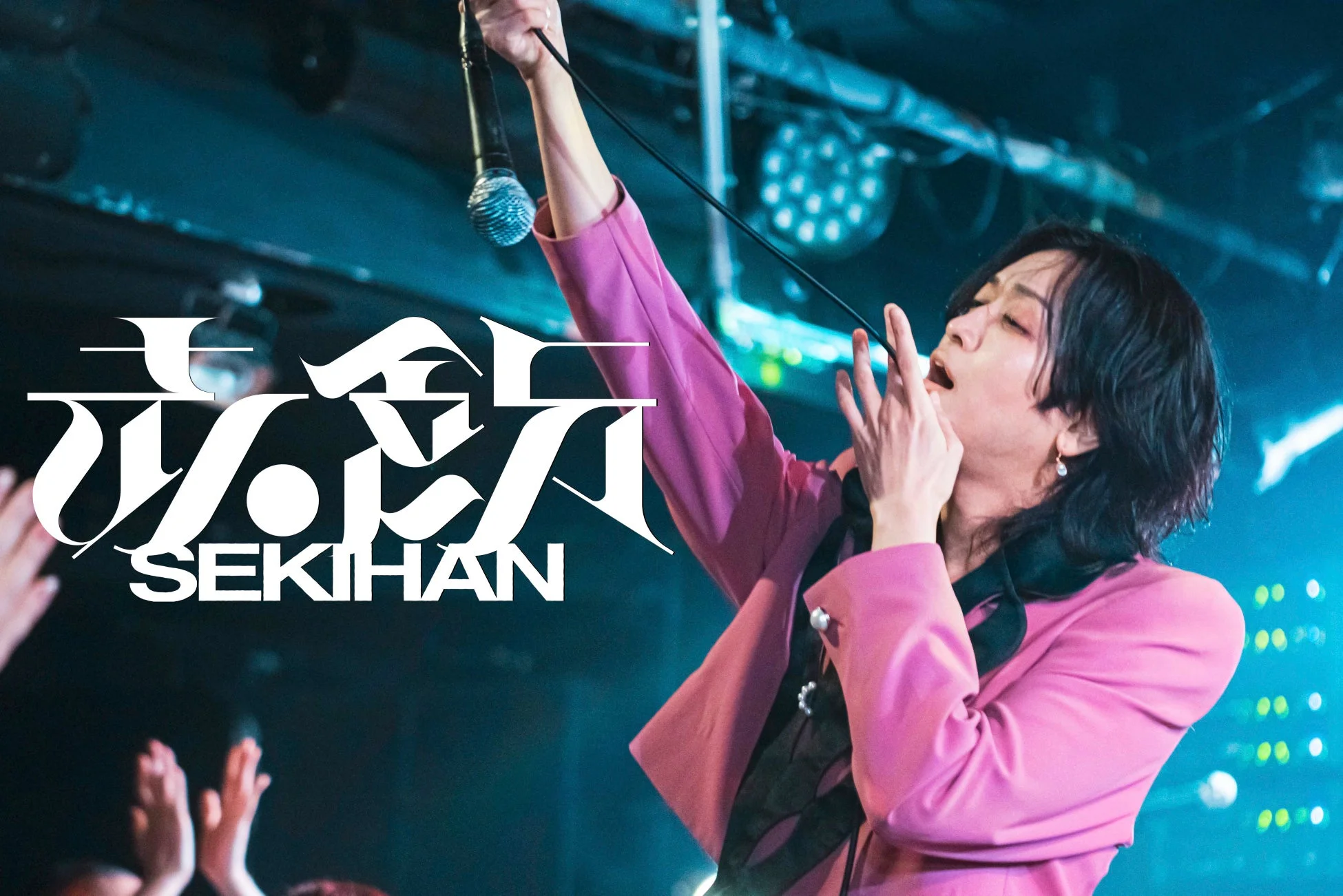 ピンクのジャケットを着て歌い上げる赤飯