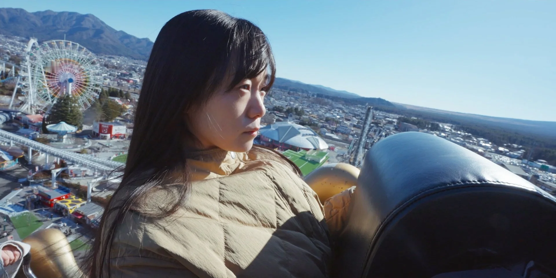 遊園地の絶叫マシンに乗る女性