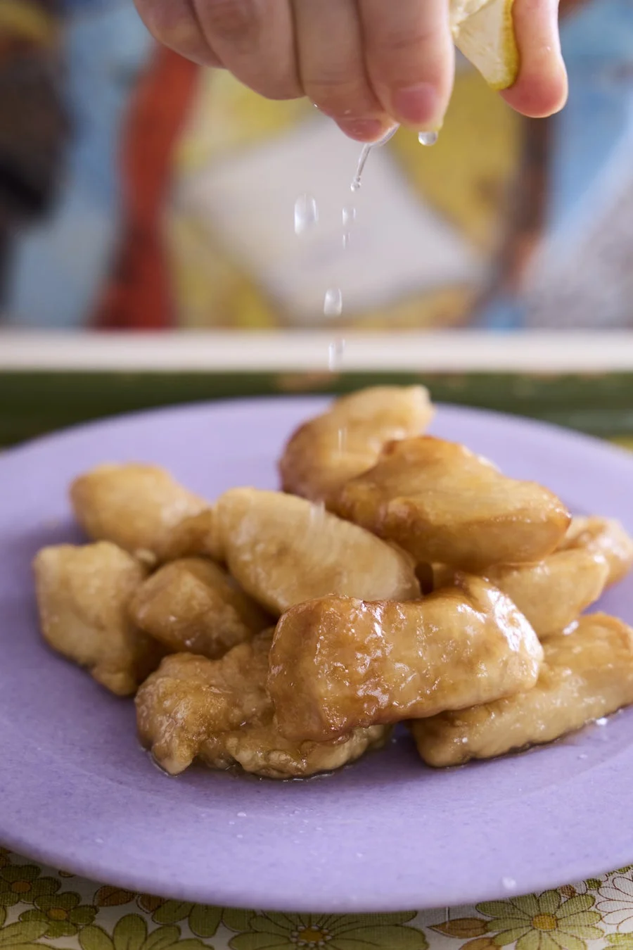 揚げ物にレモンを絞る様子