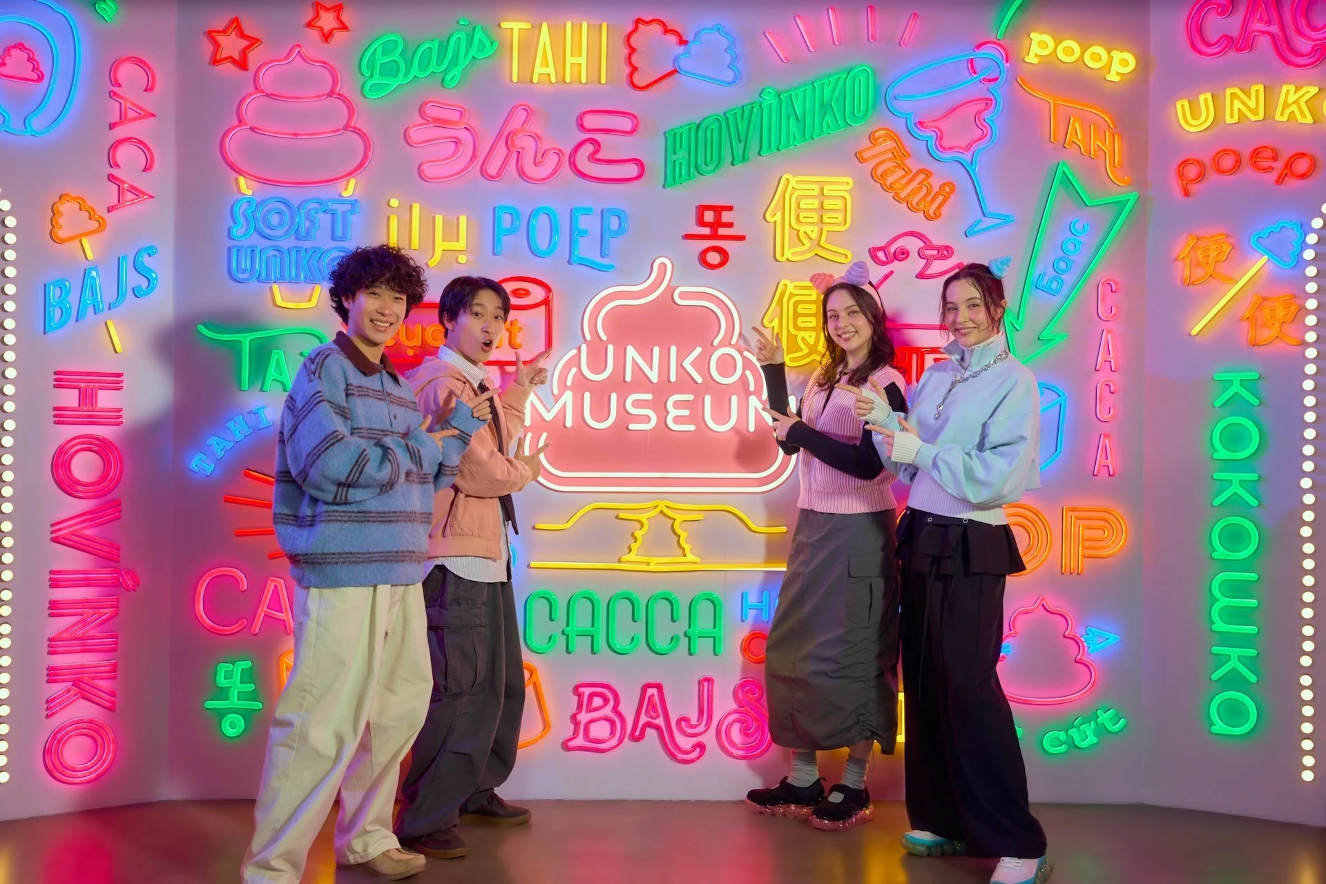 うん語ネオンの前でポーズをとる若者たち