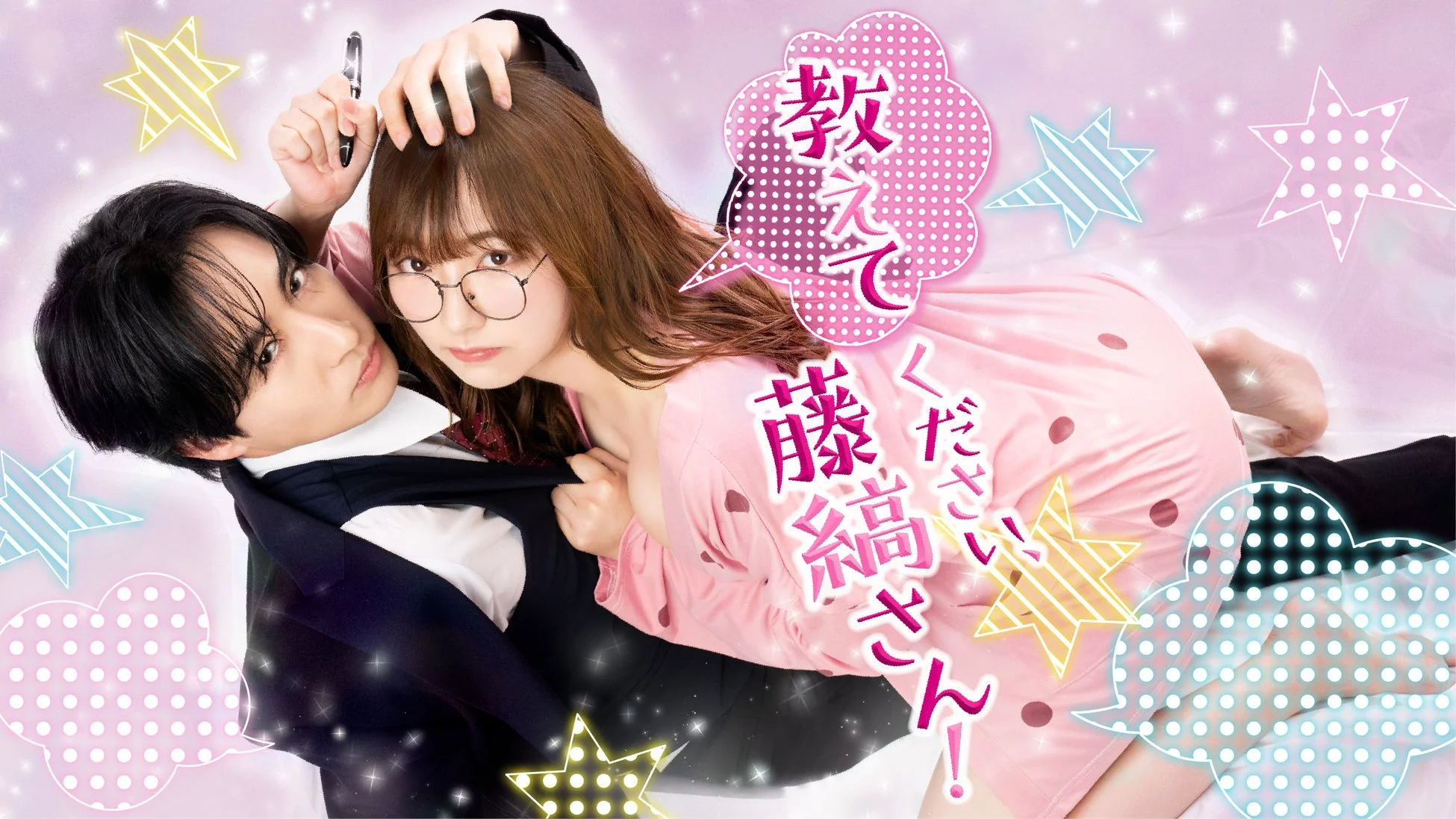 ピンクの星柄背景に、男性が女性を抱きかかえるようなロマンチックなポーズをとる二人組の画像です。女性は眼鏡をかけ、ピンクのパジャマを着てペンを持っており、男性はスーツベスト姿です。キャッチコピーは「教えてください、藤縞さん!」で、日本のドラマや漫画の宣伝ビジュアルのようです。
