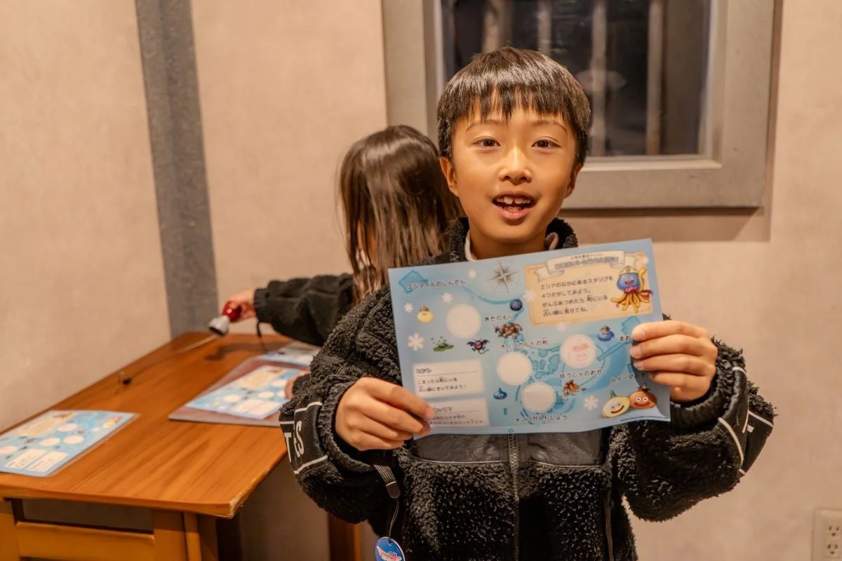 スタンプラリーの台紙を持つ少年