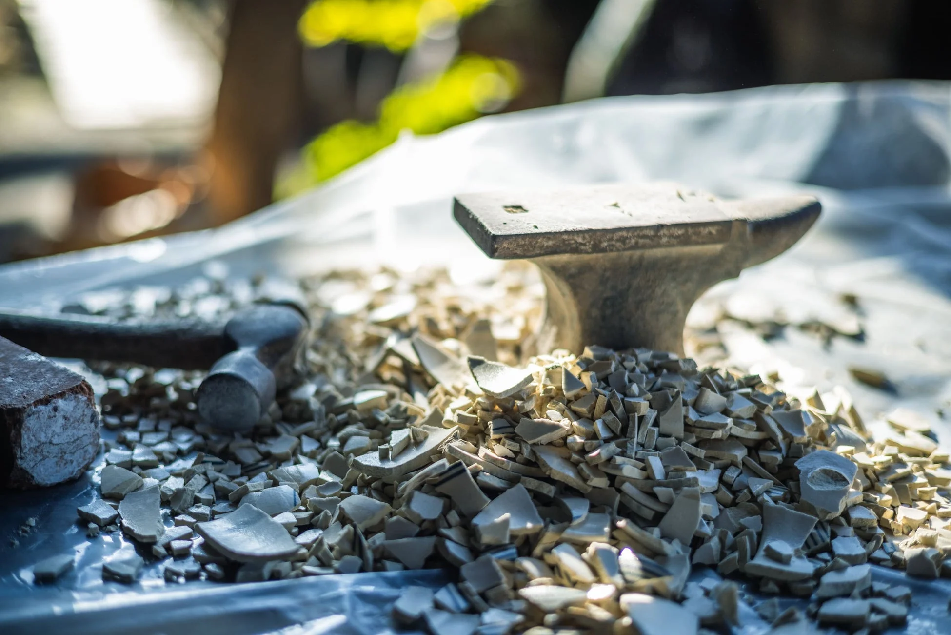 金床とハンマー、割れた陶器