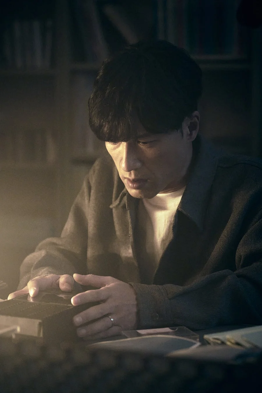 男性が手元の物体を集中して見つめる様子