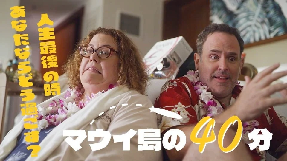 ハワイのレイを身につけ驚くカップル