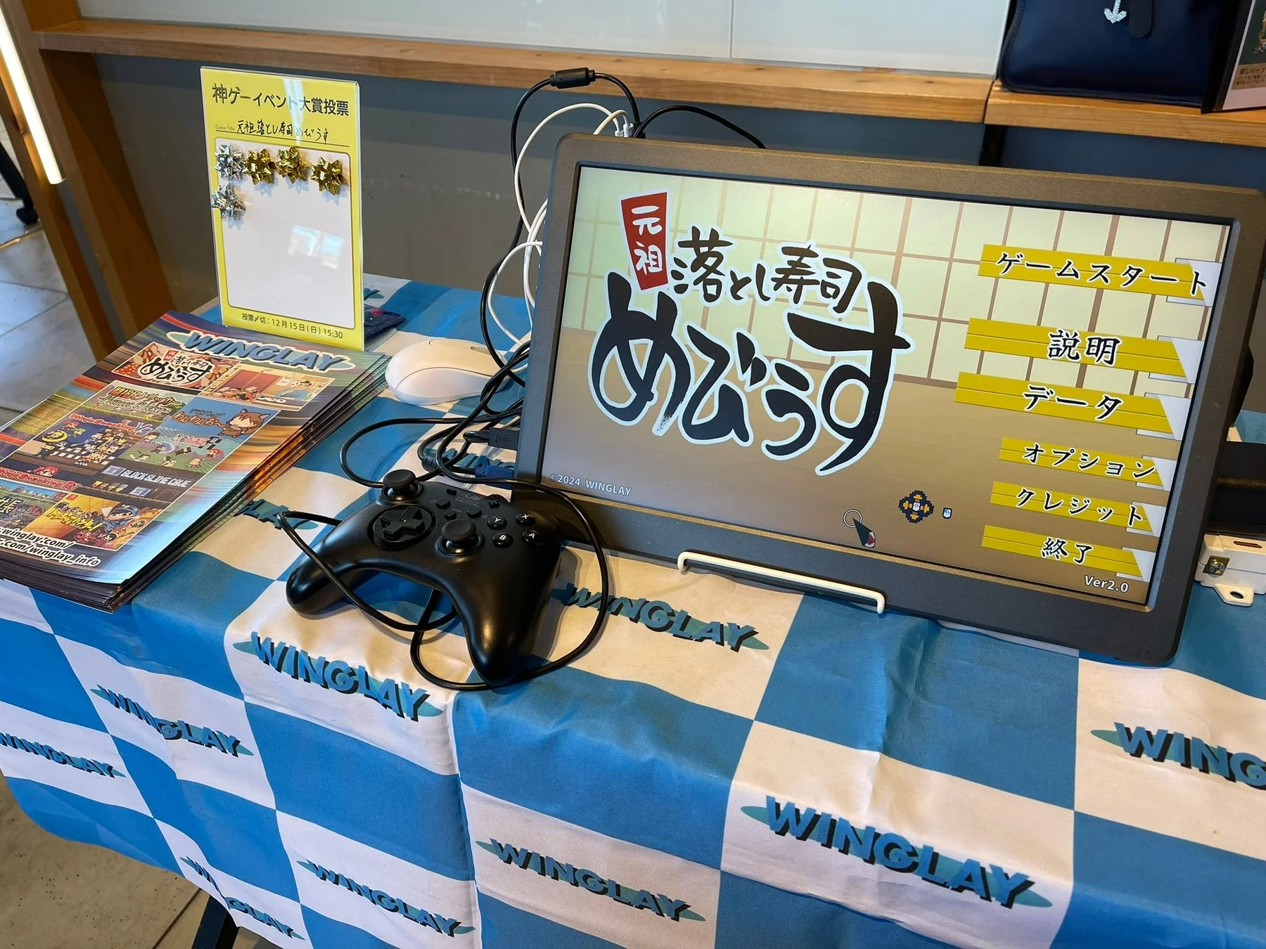 ゲームイベントのブースで、コントローラーが置かれたモニター