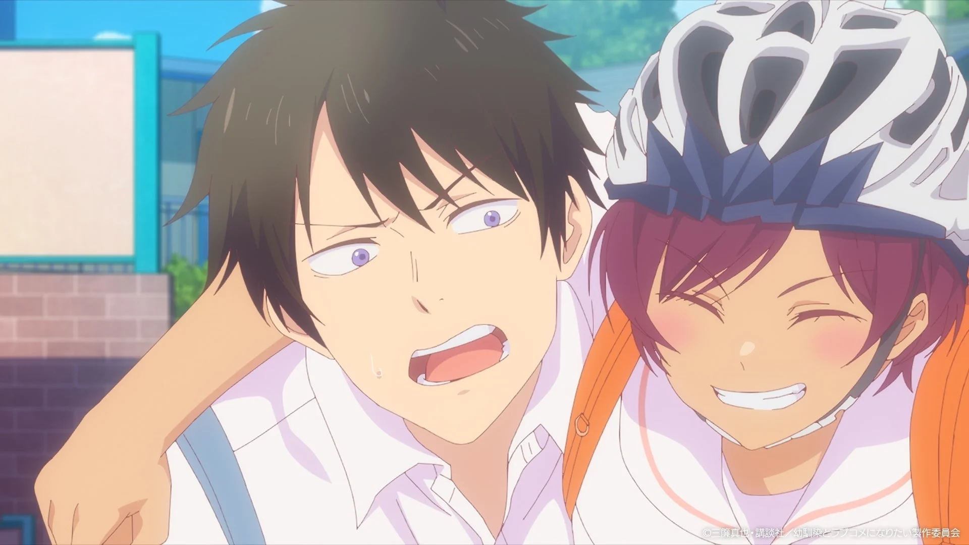 自転車用ヘルメットをかぶった笑顔の少女が、困惑した表情の少年に寄り添っているアニメのワンシーン