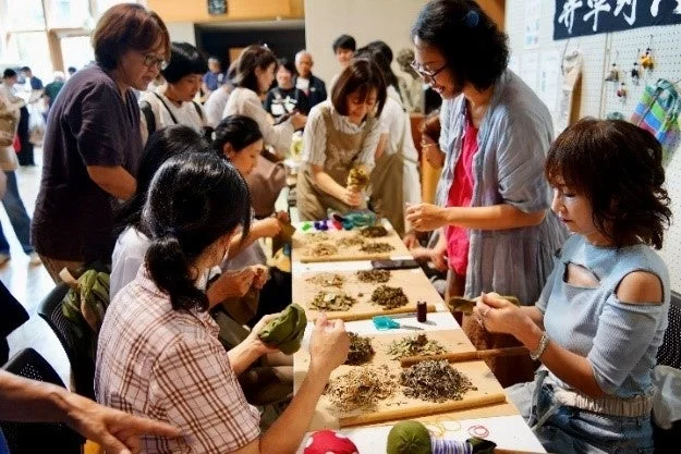 乾燥した植物素材を使って手作業を行うワークショップの風景