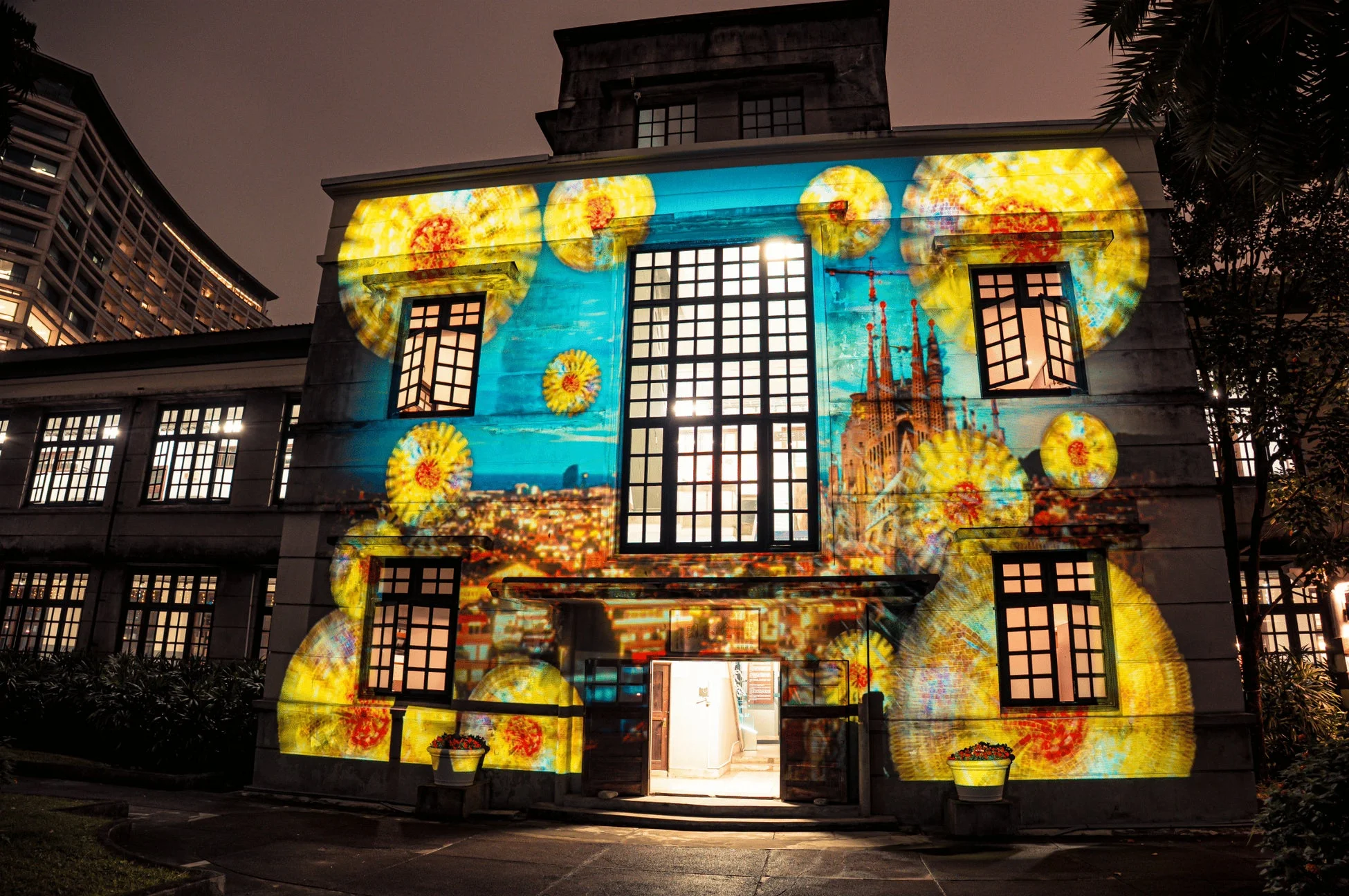夜の歴史的建造物に、ゴッホの「ひまわり」やサグラダファミリアを思わせる鮮やかなプロジェクションマッピングが映し出されている