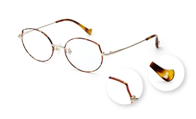 べっ甲柄のフレームとゴールドのテンプルが特徴的な眼鏡のクローズアップ画像です。テンプルの先端には可愛らしい猫のロゴがあしらわれています。