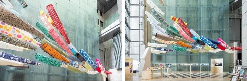 現代的な建築空間に吊るされたカラフルな鯉のぼりのアートインスタレーション