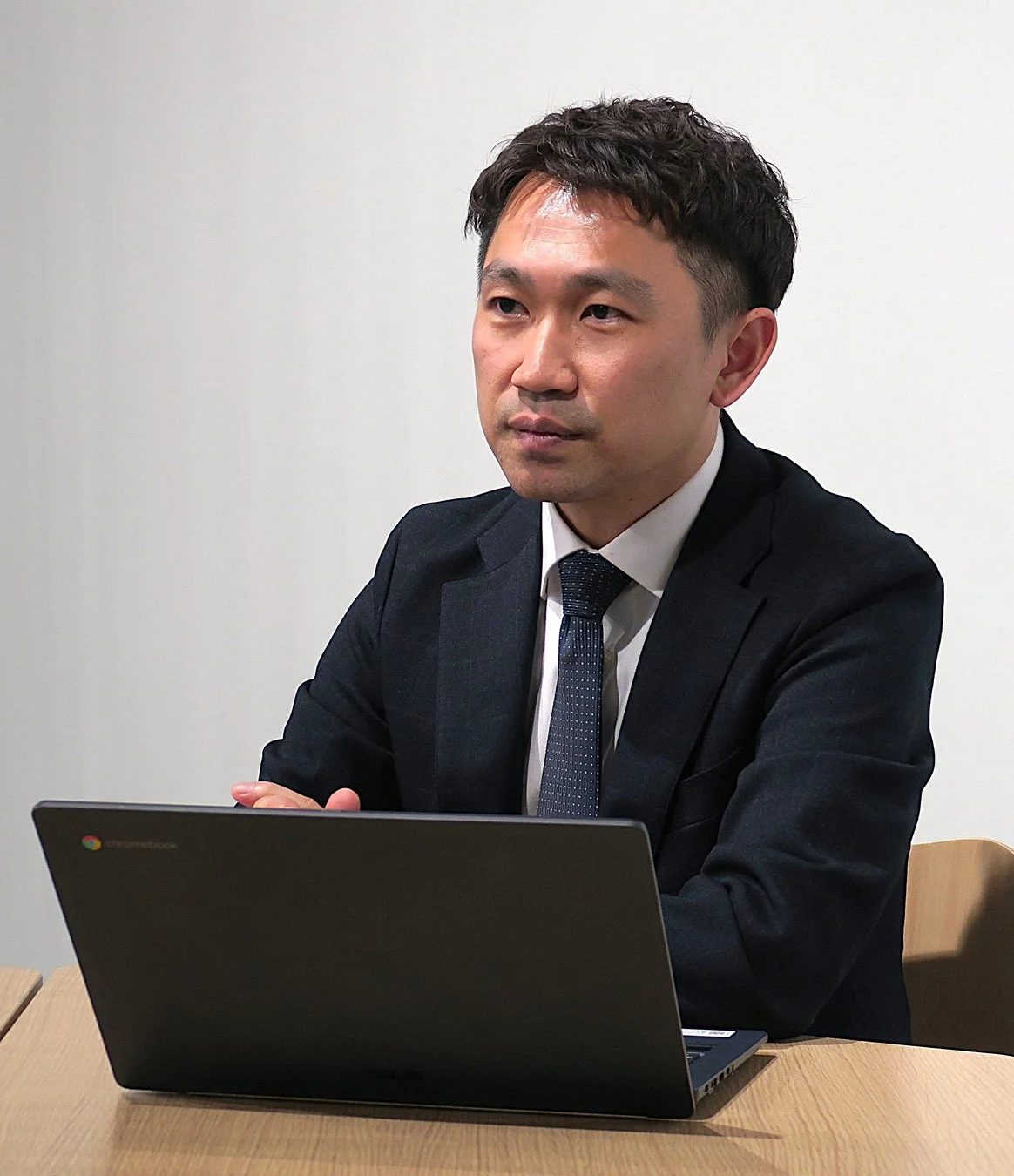 会議でパソコンを使用するビジネスマン