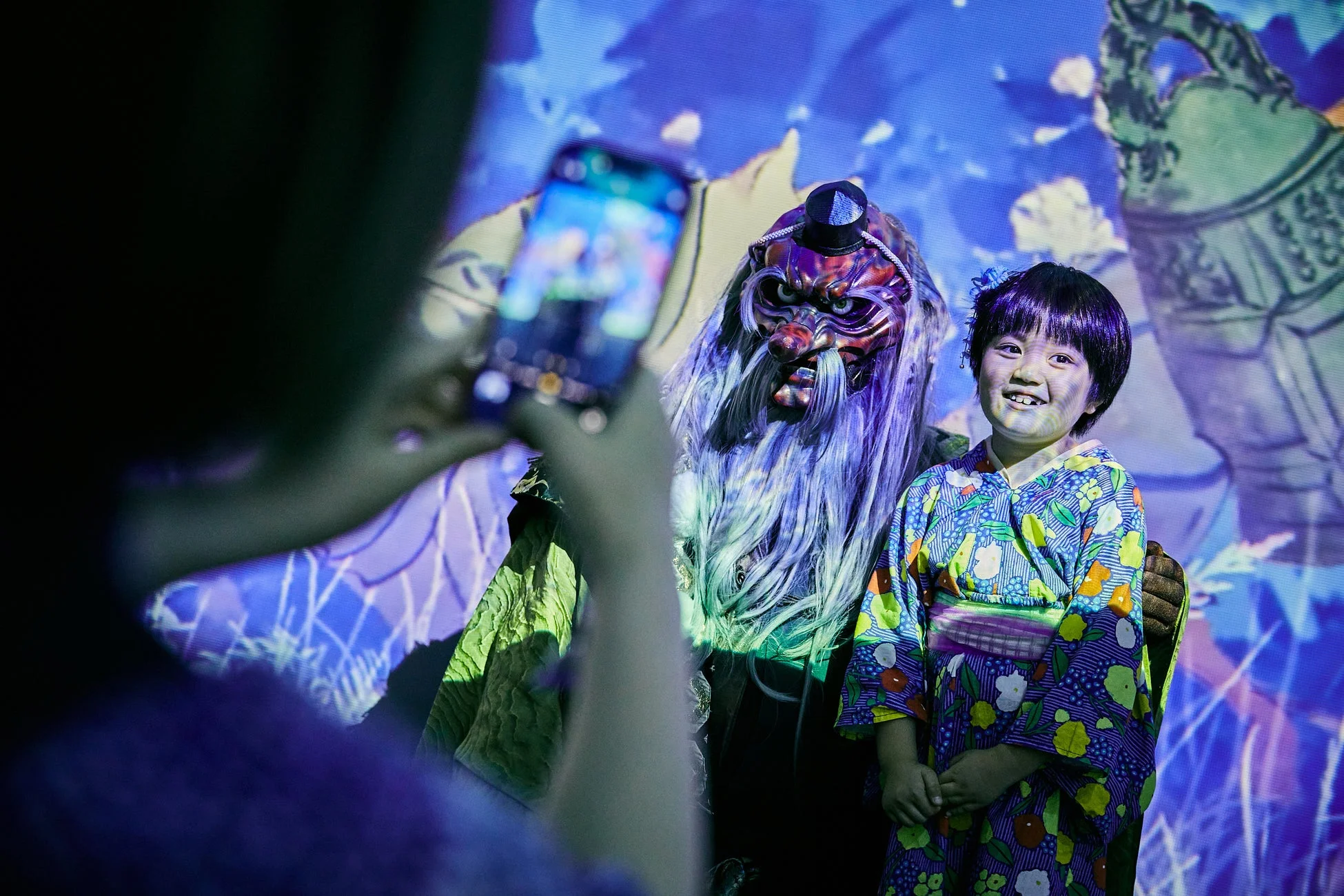 子供と伝統的な仮面をつけた人物