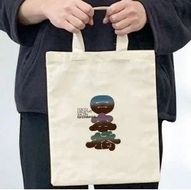 「WE'RE ALL ON THE SAME BALL」という文字と、カラフルな石のようなデザインが描かれたトートバッグ