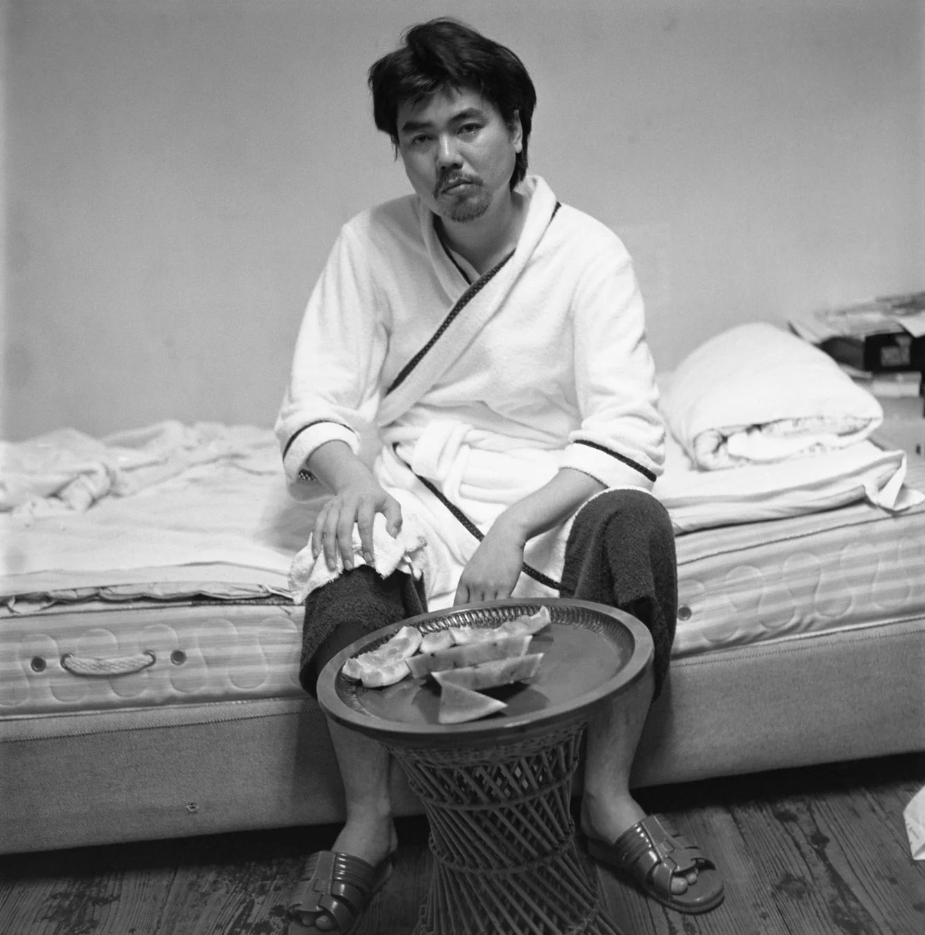 バスローブ姿の男性とスイカのモノクロ写真