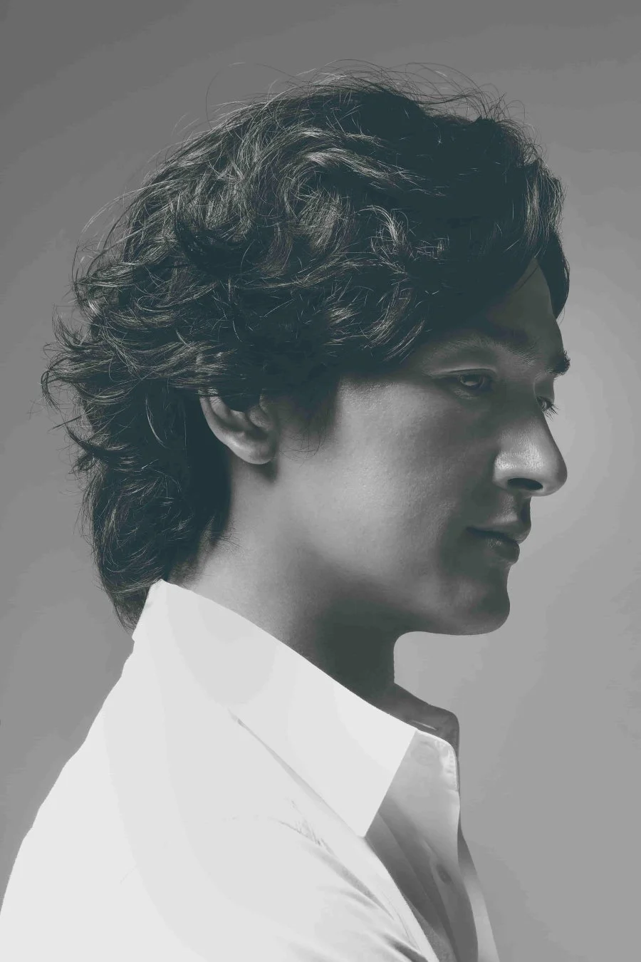 白いシャツを着た男性の横顔を捉えたモノクロのポートレート