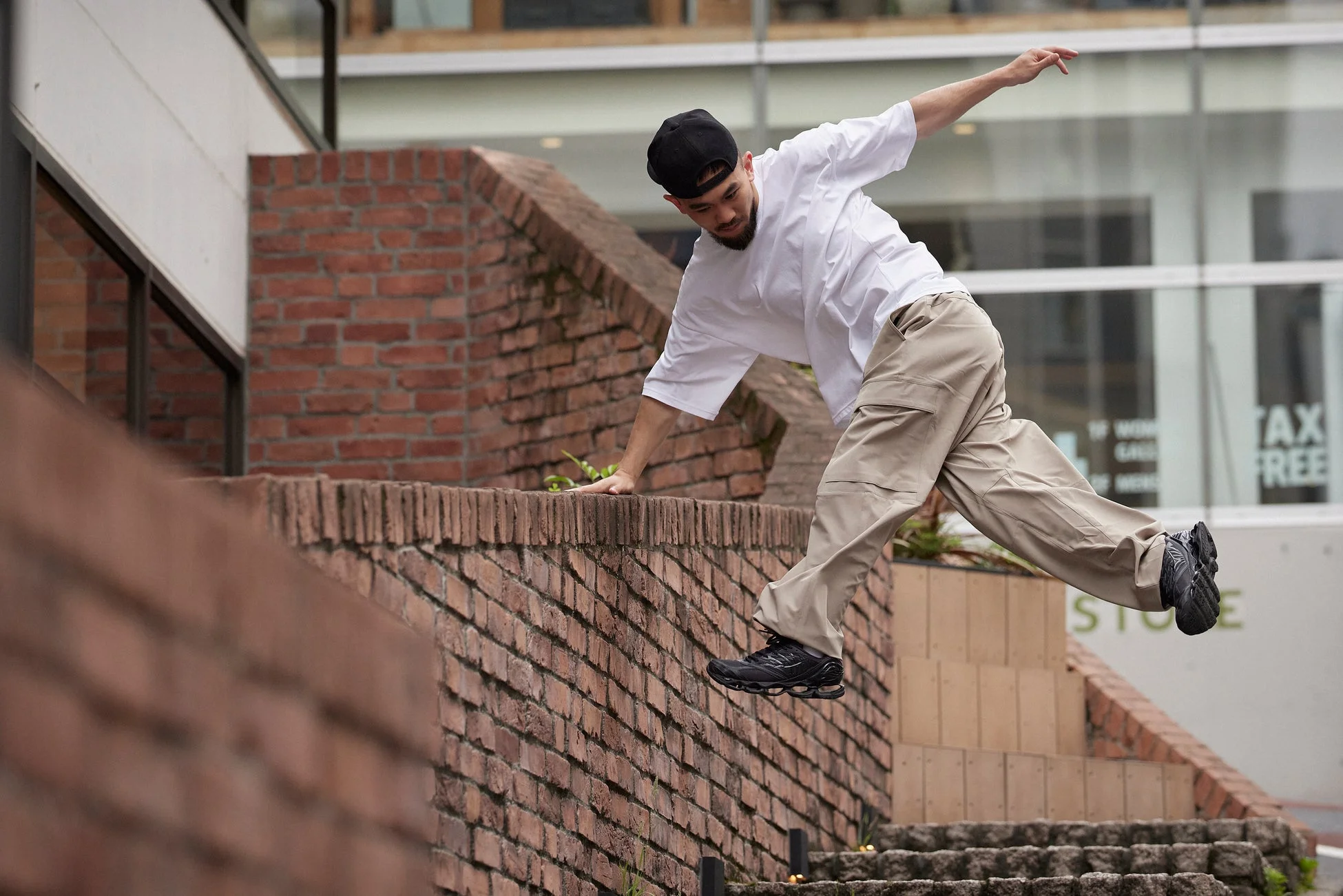 レンガの壁を飛び越える男性