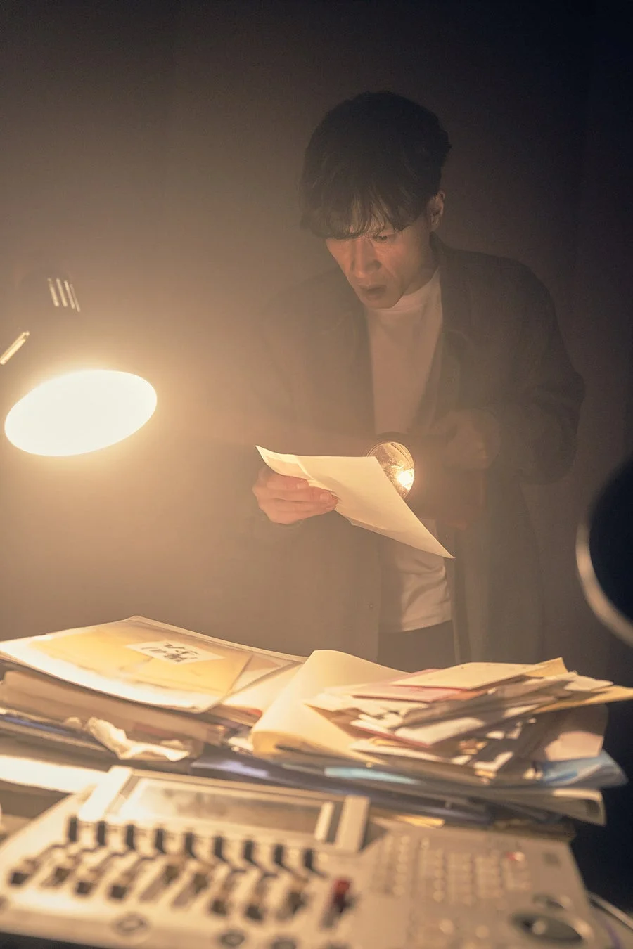男性が懐中電灯で書類を調べる様子