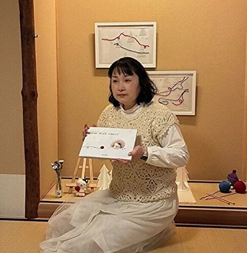 和室の畳に座り本を読む女性