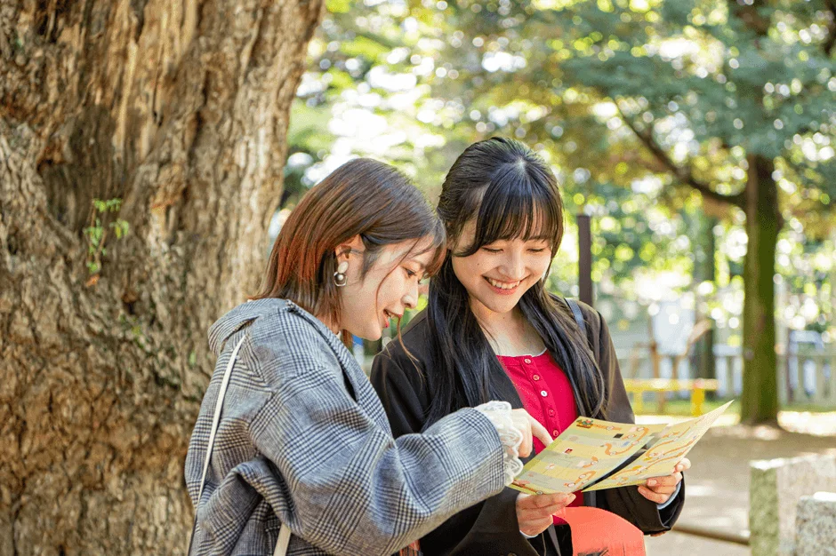 地図を広げて笑顔の女性2人