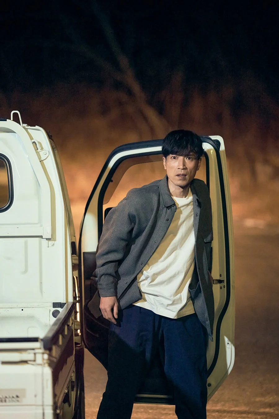 男性が軽トラックから降りる場面