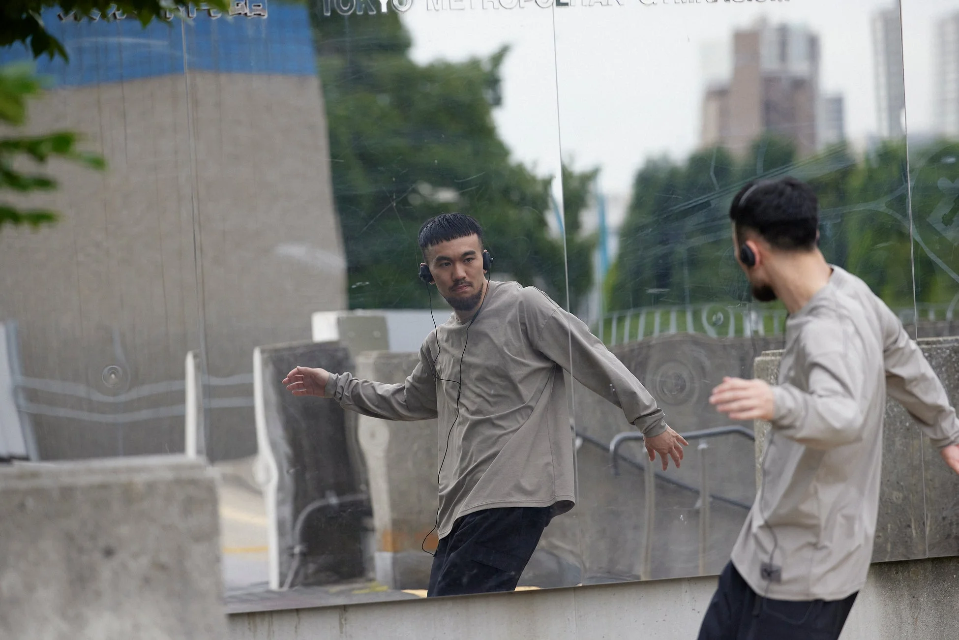 東京体育館を背景にヘッドホンの男性