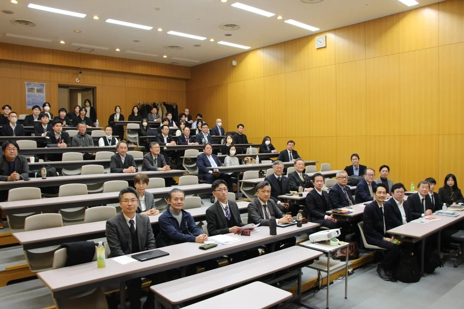 講義室で多くの聴衆が講演を聴いている様子