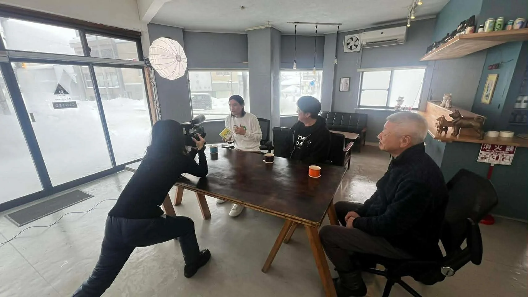 雪景色を背景にインタビュー撮影が行われている様子