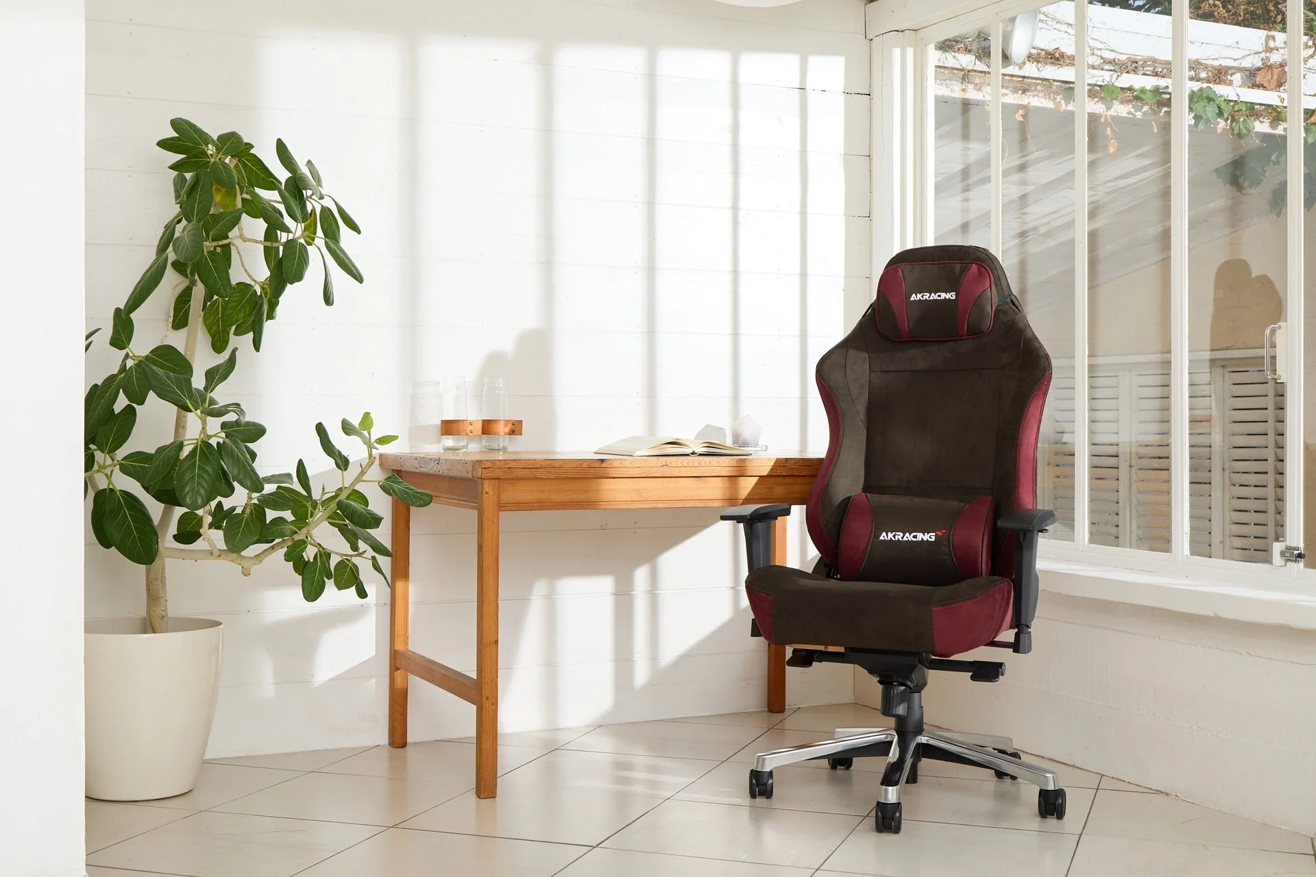 ブラウンとワインレッドのAKRacing FAURAチェアが置かれた落ち着いた作業空間