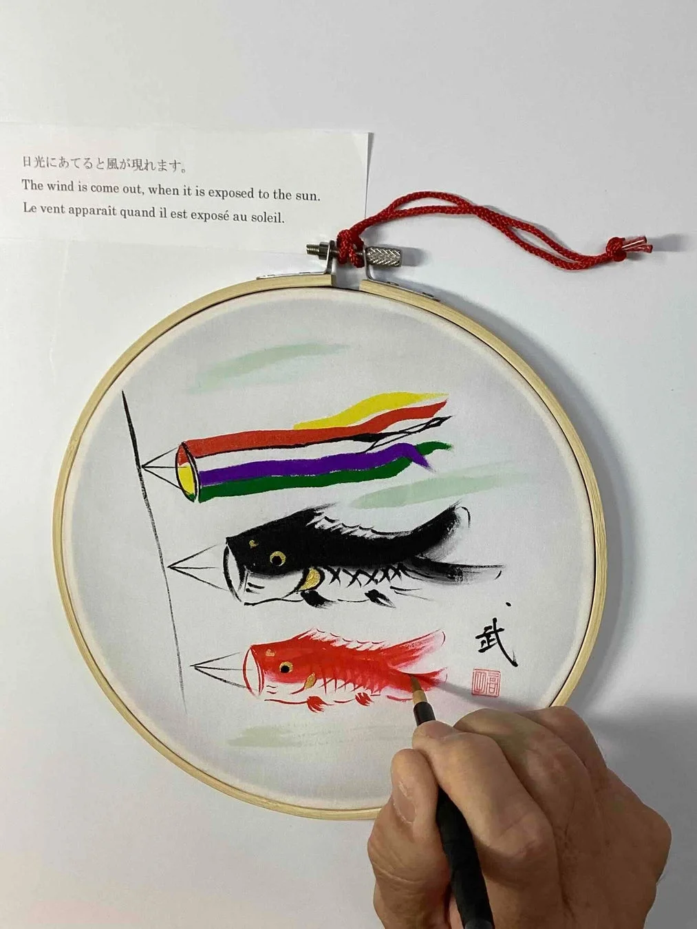 筆で鯉のぼりを描く手元