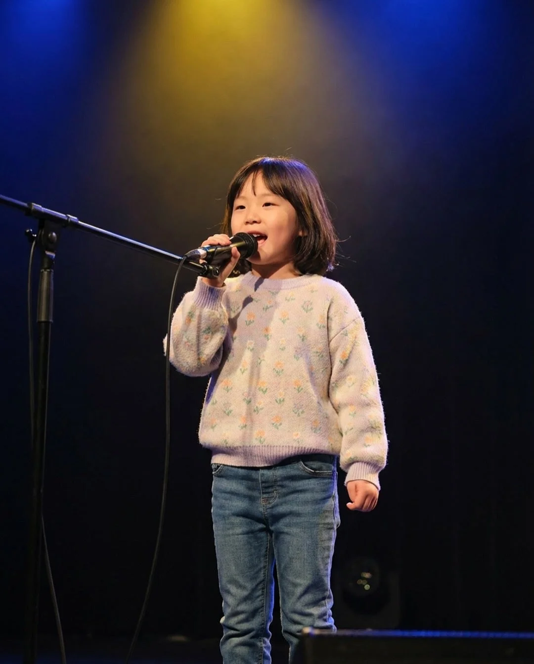 マイクを持って歌う少女