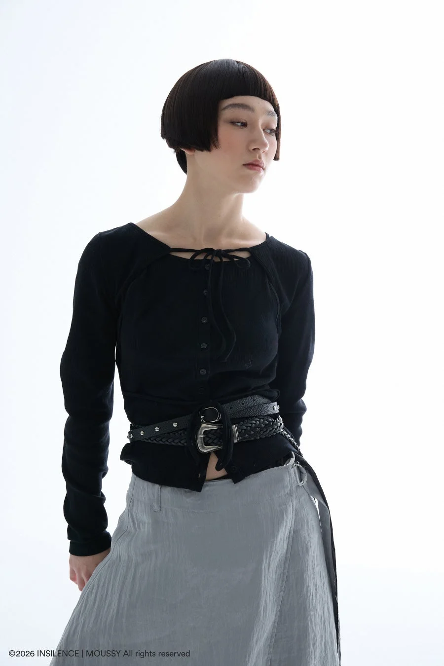 黒トップスとベルト、グレースカートのミニマルなファッション