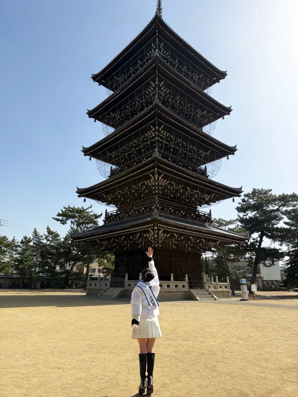 五重塔を背景に手を伸ばす信濃宙花さん