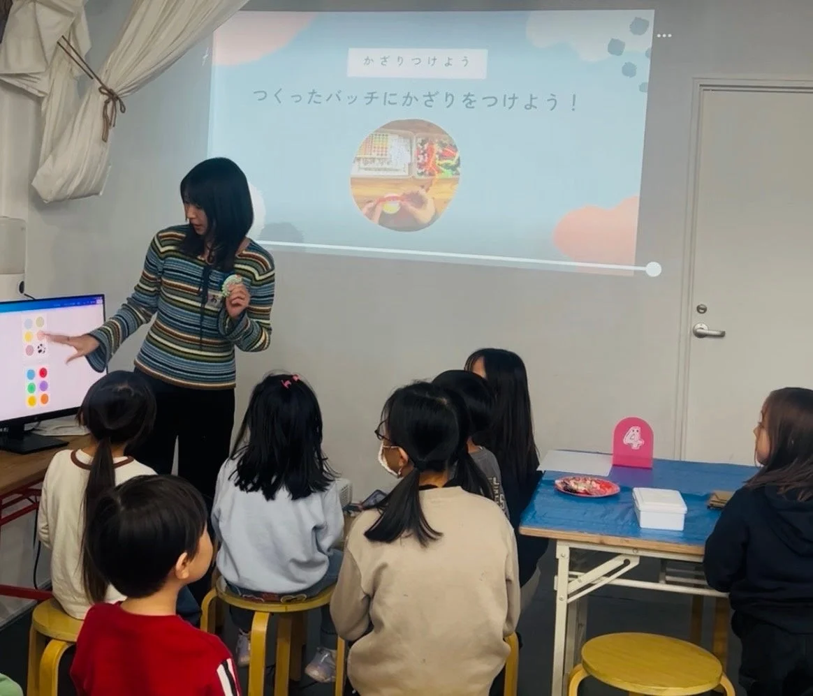講師が子供たちにクラフトを教えている様子