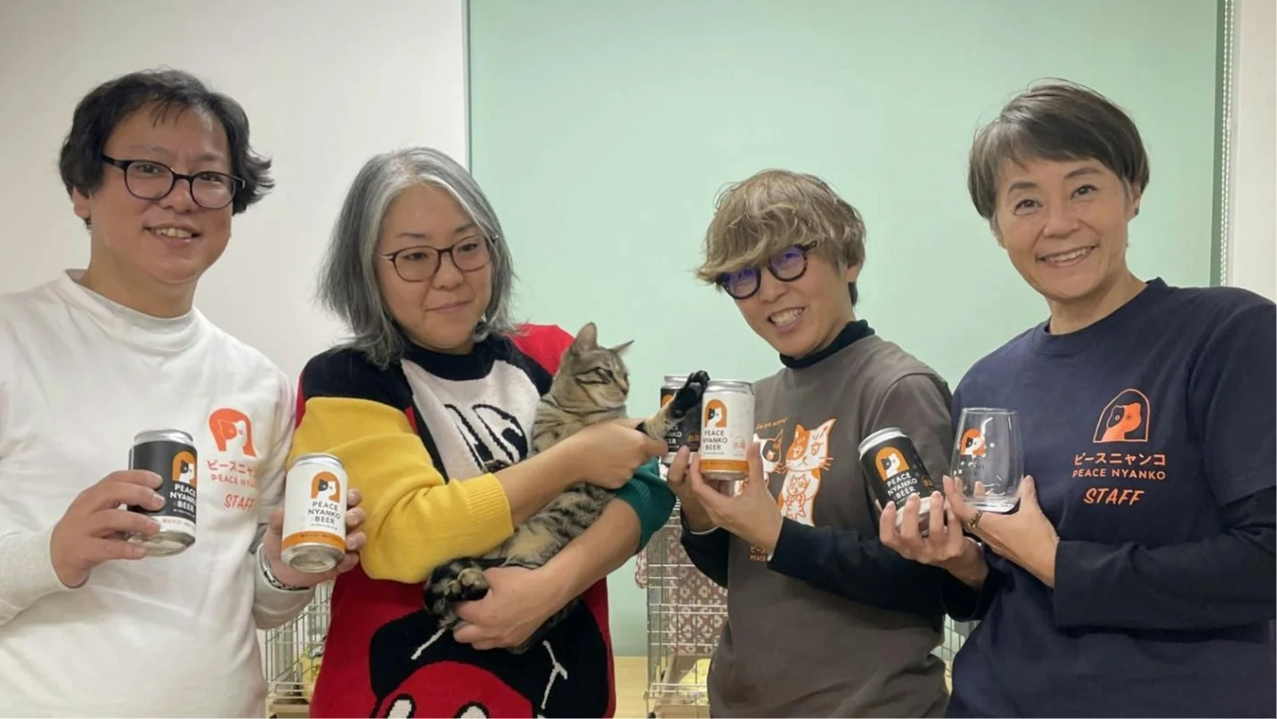 ピースニャンコスタッフがビールを手に猫を抱いている様子と、移動式手術室となるバン