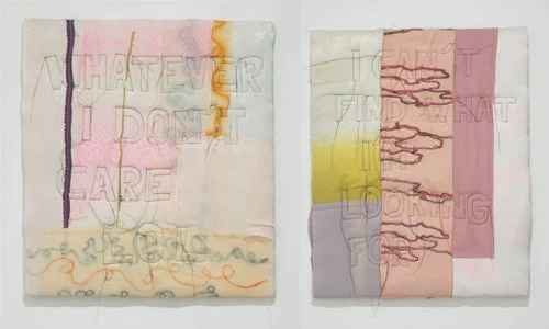 淡いパステルカラーの布地にメッセージが縫い付けられた2枚のテキスタイルアート作品。