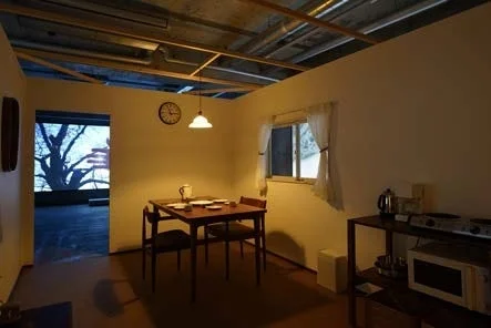 暖色系の照明が灯る室内空間に、裸の木のシルエットがプロジェクションで映し出されている