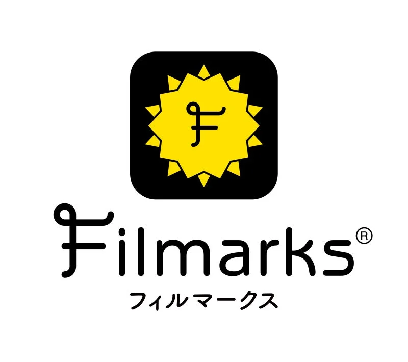 Filmarksリバイバルのロゴマークです。白背景に黒い文字で「Filmarks」と「フィルマークス」と書かれ、上部には黒い四角いアイコンに黄色い星のような図形と筆記体のような「F」の文字が描かれています。
