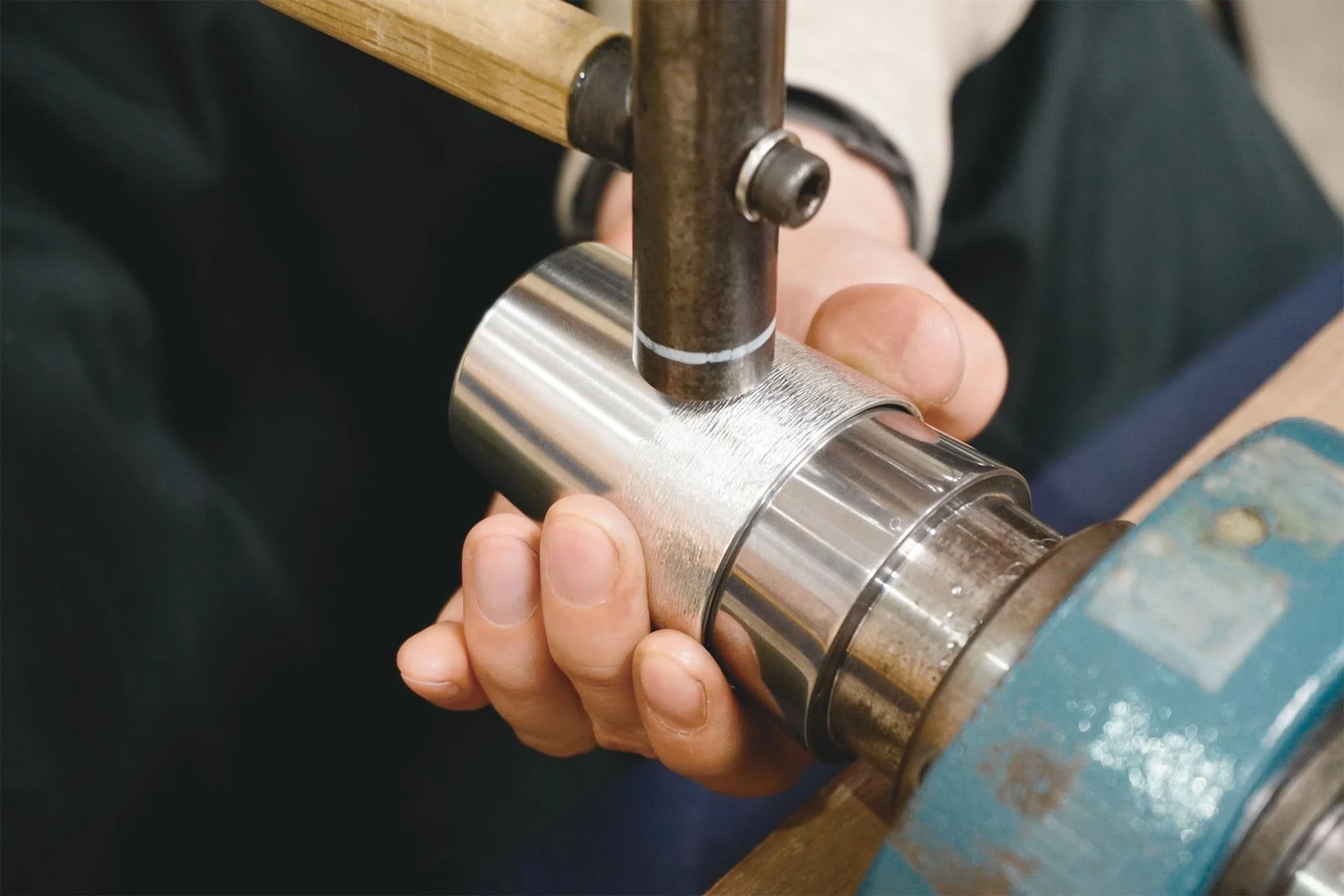 職人が金属製の円筒を加工する様子