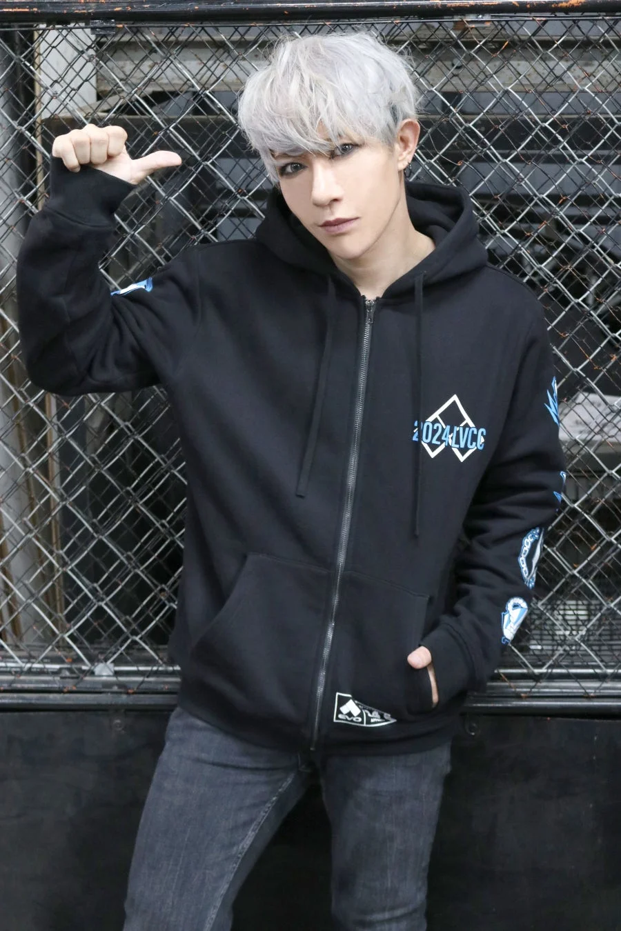 ワイヤーフェンスの前でポーズをとる歌広場 淳さん