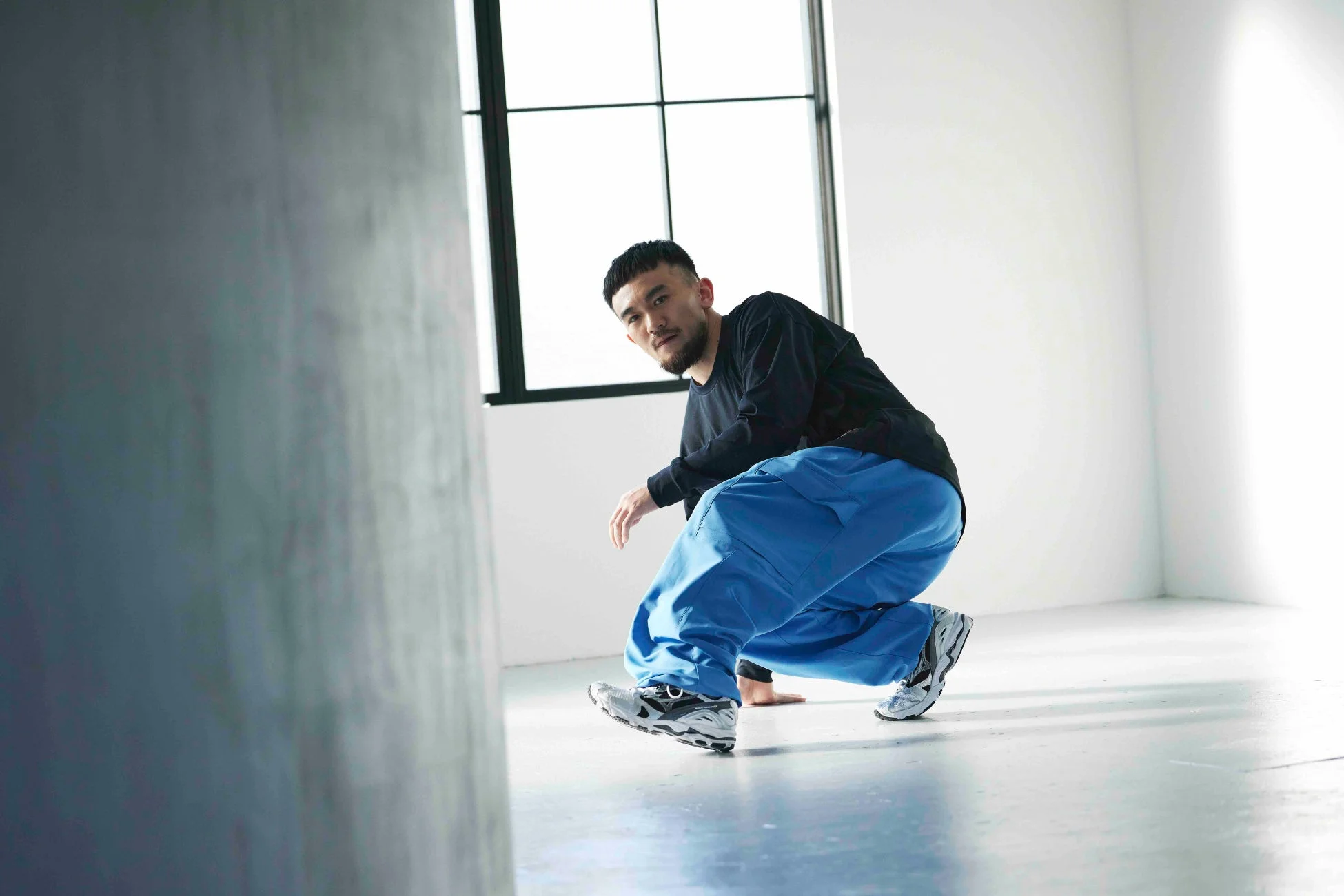 窓際でポーズをとる男性