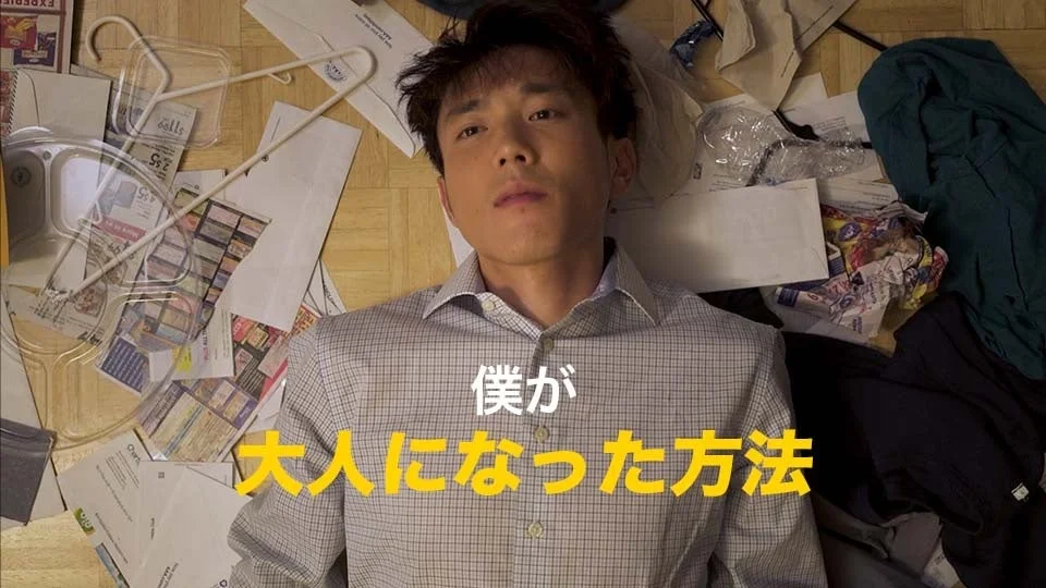 散らかった部屋で床に横たわる男性