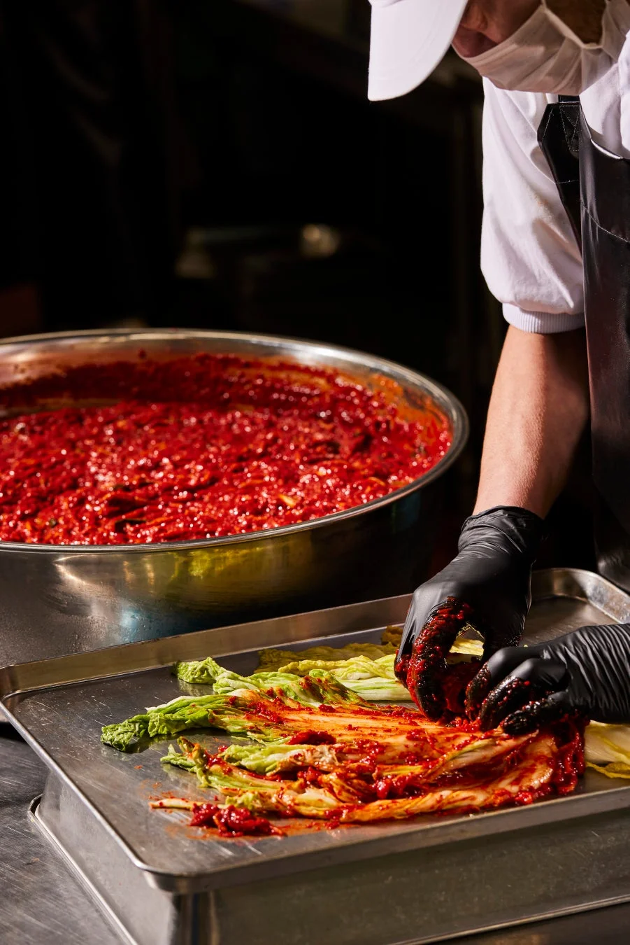 キムチの素を白菜の葉に丁寧に塗り込んでいる様子