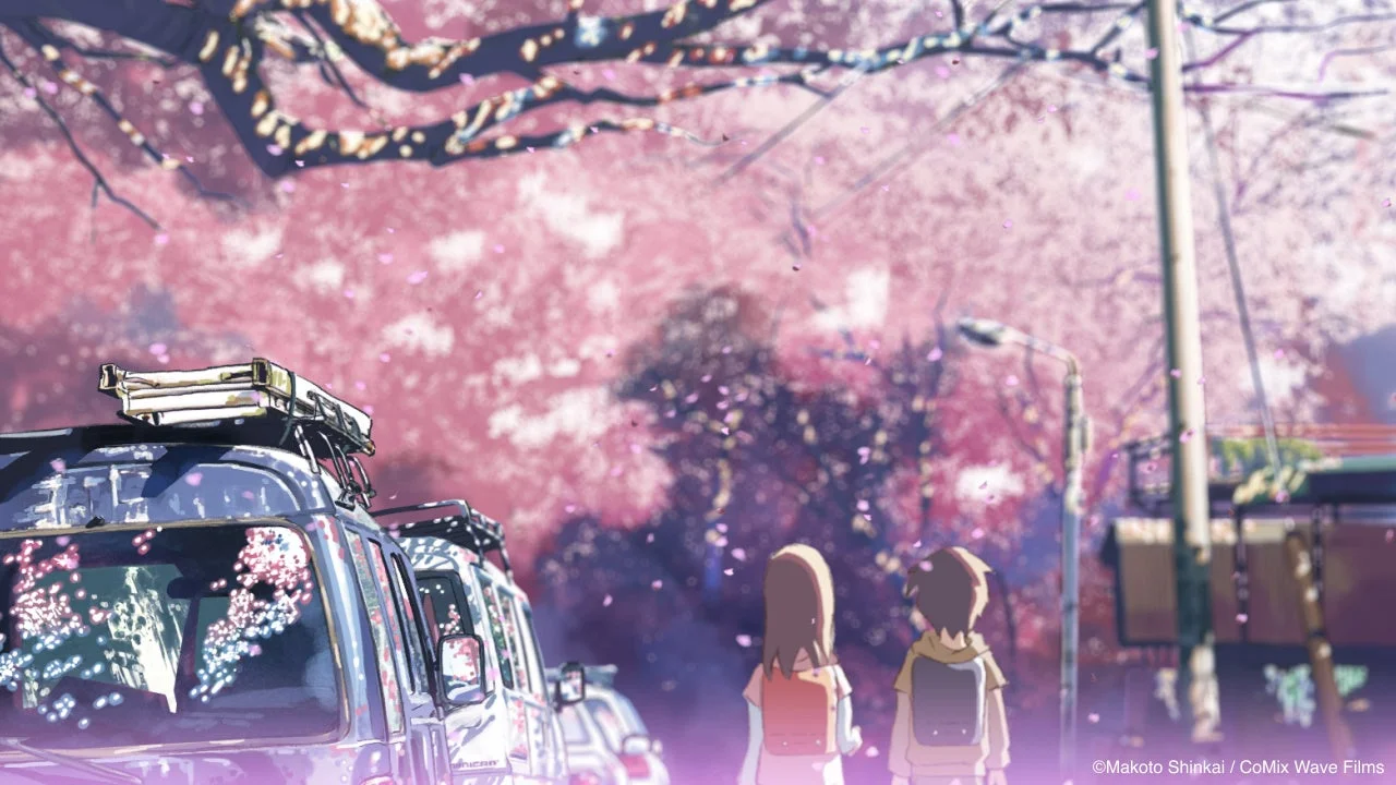 桜吹雪が舞う春の道を、ランドセルを背負った少年と少女が歩いているアニメーションの風景